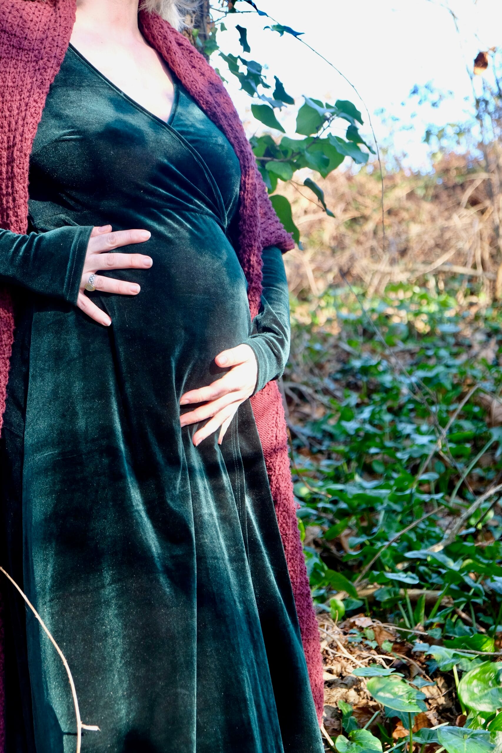 Photo d'une femme enceinte dans la nature. Elle est apaisée, caressant son ventre. Communiquant avec son bébé.
